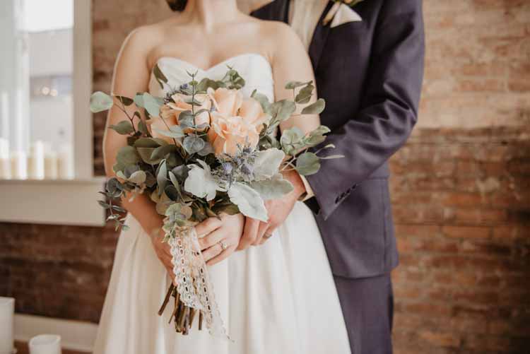 coppia di sposi con un bouquet in mano